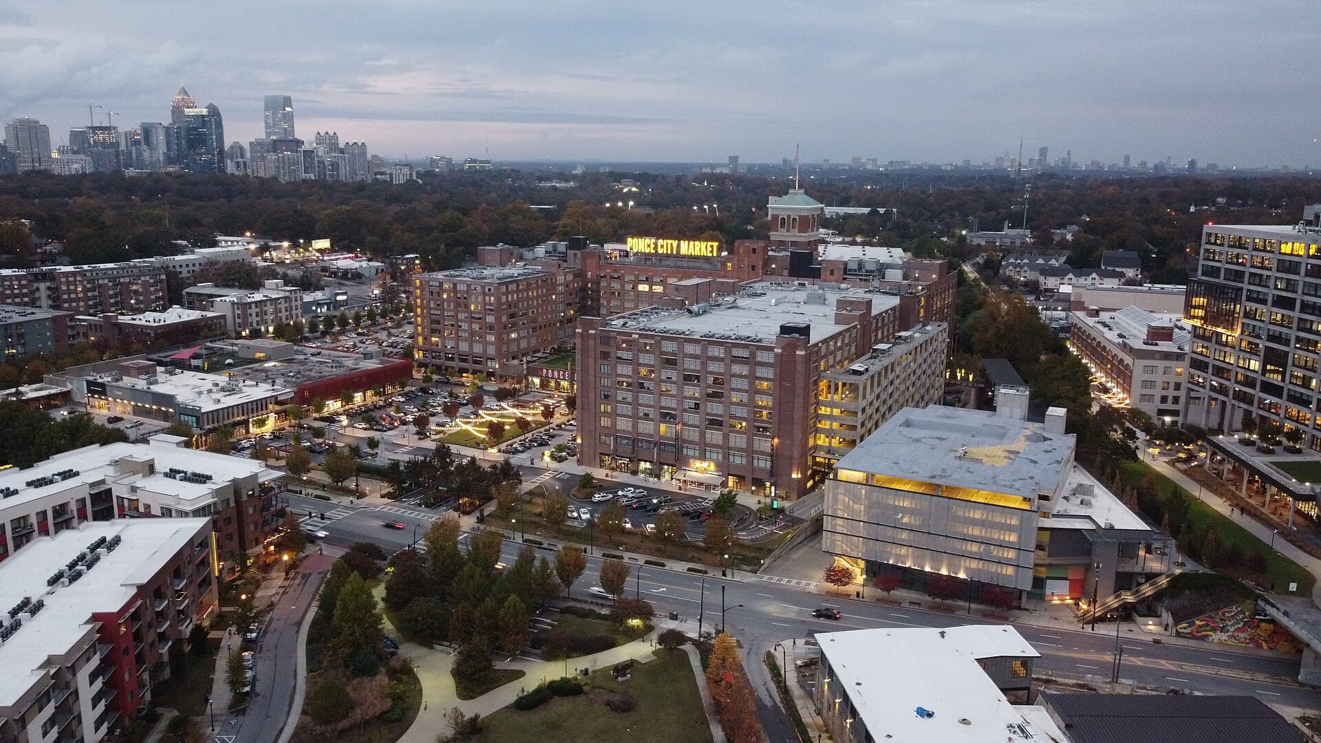 Ponce City Market at dusk with the Midtown Atlanta skyline behind it
